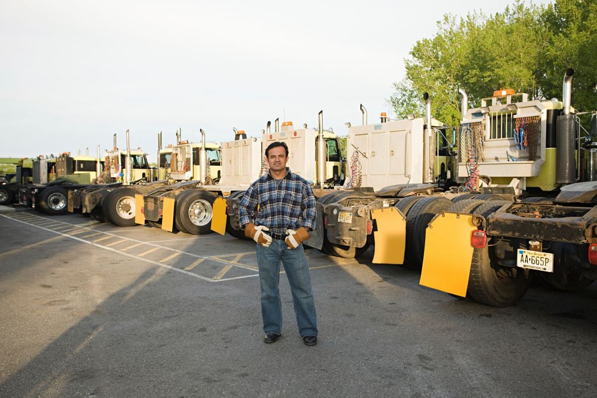 Truckers Authority team member standing in front of a fleet of trucks